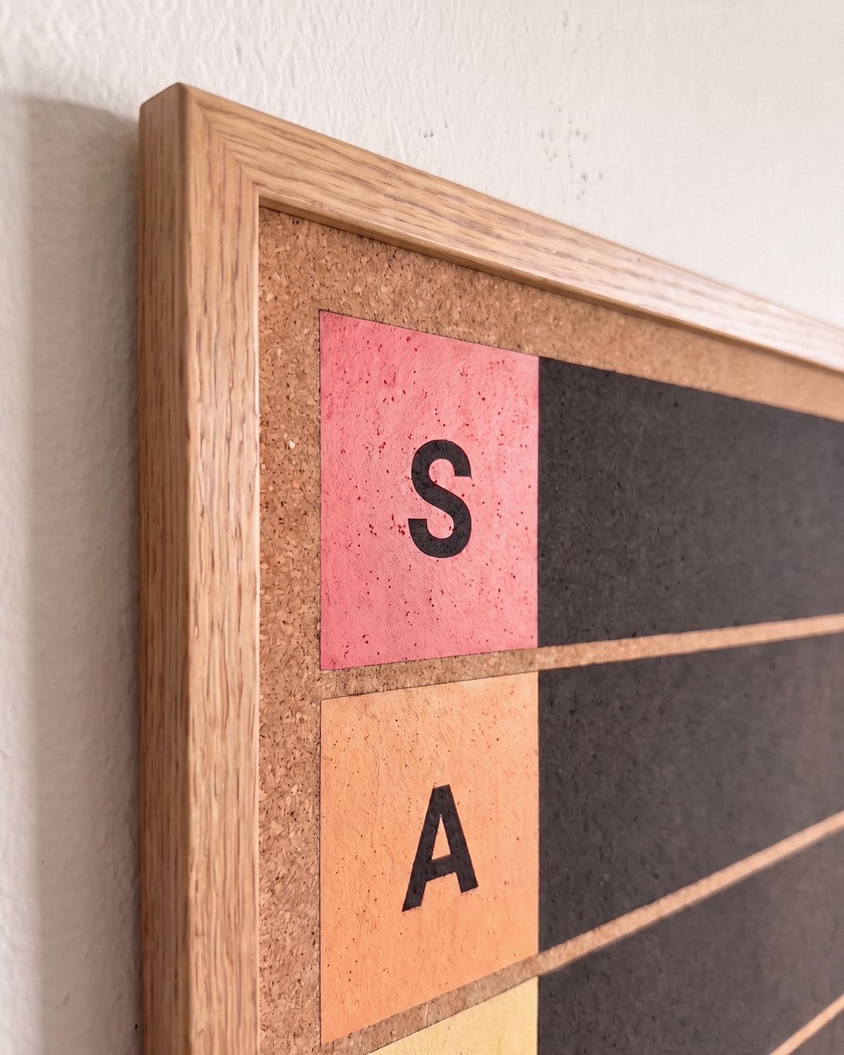 Real wood frame: A slim real wood frame with a satin finish. Natural oak finish, black or white. It sits just under an inch off the wall and arrives ready to hang.